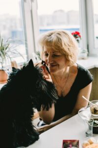 Woman Holding Treat for her black scottish terrier