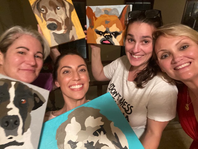 Mom and daughter painting their pet portraits together smiling and happy.